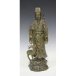 A Chinese cast bronze figure of an immortal, 20th century, modelled standing and accompanied by a