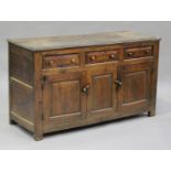 An 18th century oak dresser base, fitted with three frieze drawers above cupboards, on block legs,