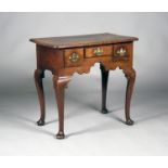 An 18th century and later walnut lowboy, the moulded top above three drawers and a shaped apron,