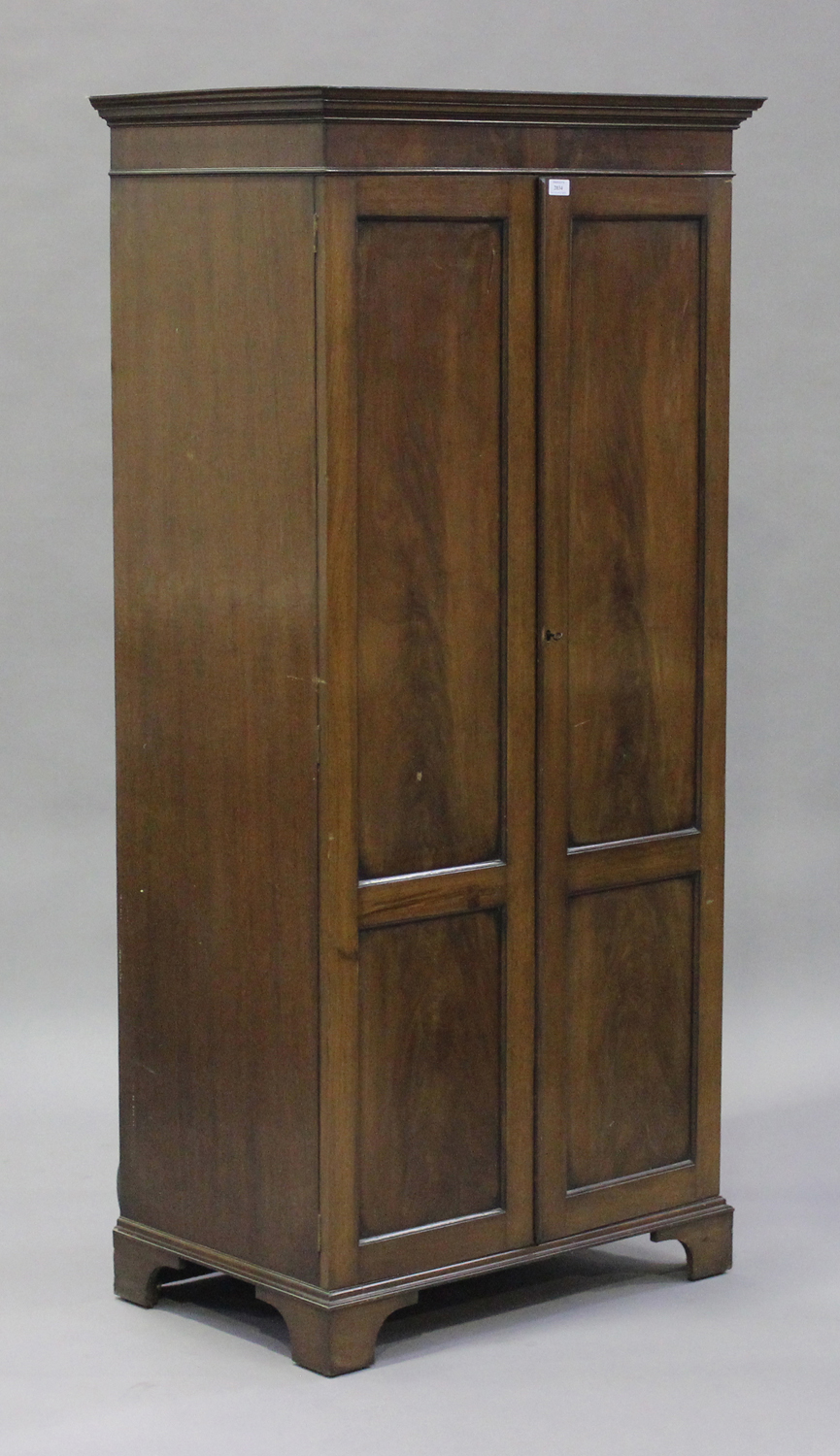 A 20th century Victorian style figured mahogany gentleman's two-door wardrobe, retailed by