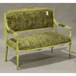 An early 20th century French cream painted two-seat salon settee, the upholstered seat and back