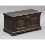 A small 18th panelled oak coffer, the hinged lid above a double-panel front, raised on shaped