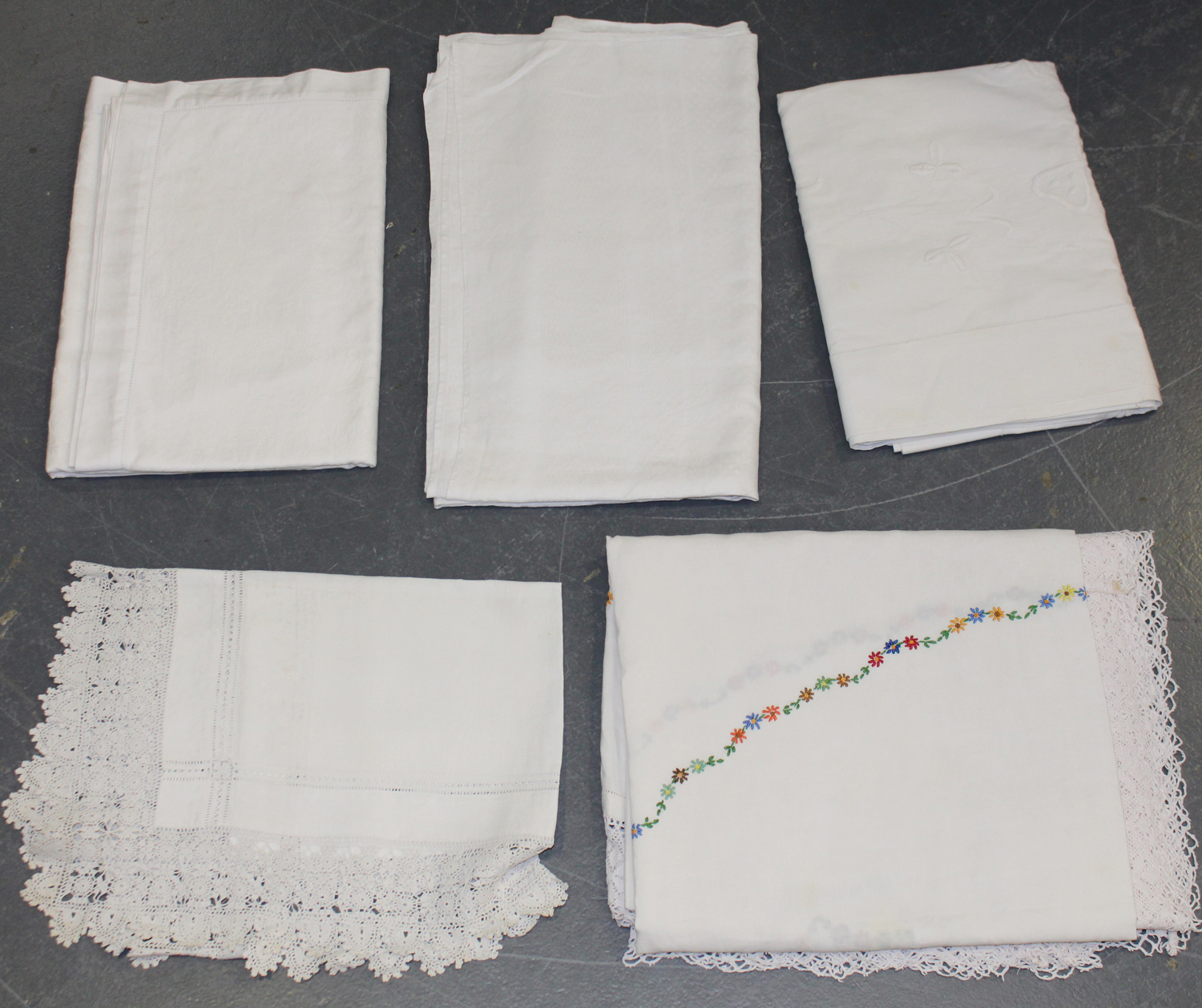 A group of whitework, including linen and damask tablecloths and a lacework frieze.Buyer’s Premium