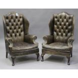 A pair of 20th century George III style brown leather wingback armchairs with brass studwork