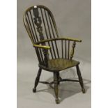 A 19th century ash and elm pierced splat back Windsor armchair, the solid seat raised on turned legs