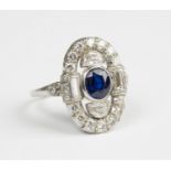 A platinum, diamond and sapphire panel shaped cluster ring, mounted with the oval cut sapphire