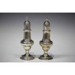 A George III silver caster of baluster form with pierced domed cover and spiral finial, on a