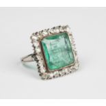 A white gold, emerald and diamond square cluster ring, mounted with a large square cut emerald