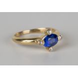 A gold, sapphire and diamond ring, mounted with an oval cut sapphire within a surround of four