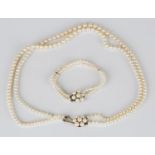 A two row necklace of graduated cultured pearls on a 9ct gold, cultured pearl and diamond clasp,