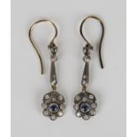 A pair of silver, diamond and sapphire pendant earrings, the terminals designed as floral