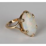 A gold ring, claw set with an oval opal, ring size approx O1/2.Buyer’s Premium 29.4% (including