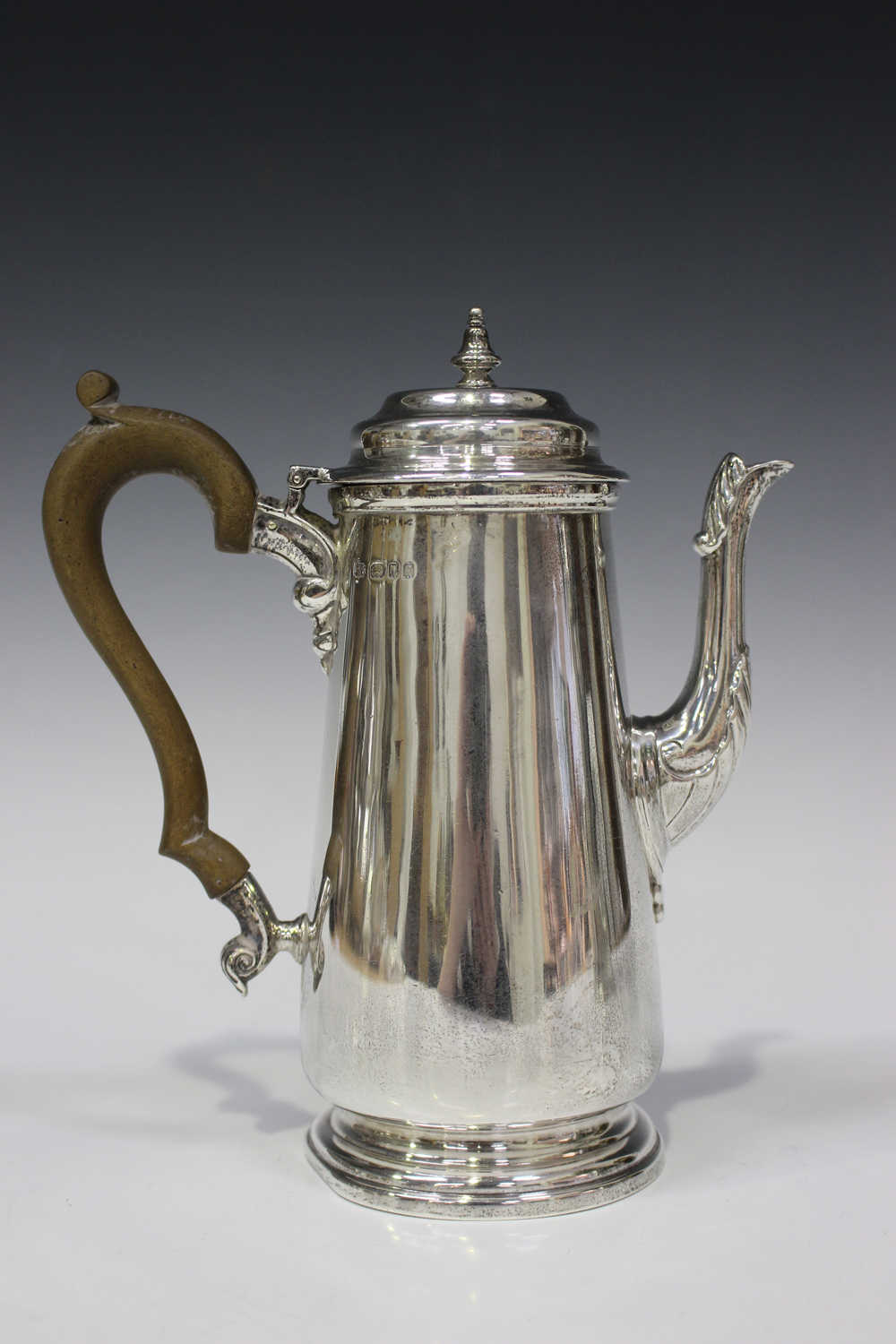 A George V silver coffee pot of tapered cylindrical form, the domed hinged lid with turned finial