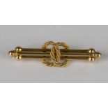 A gold bar brooch in an interlooped ropetwist and triple bar design with beaded terminals,