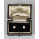 A pair of gold and cultured pearl dress studs, detailed '18ct', with a case.Buyer’s Premium 29.4% (