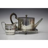 A George III silver oval teapot, engraved with a crest in a circular pendant cartouche between