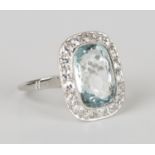 An aquamarine and diamond curved rectangular cluster ring, collet set with a curved rectangular
