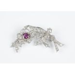 A diamond and ruby brooch, designed as a floral spray, the flowerhead centre claw set with a cushion