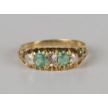 A gold, emerald and diamond five stone ring, mounted with two cushion cut emeralds alternating