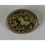 A gold mounted Indian green Pertubghar glass oval brooch, decorated with an antelope and calf and