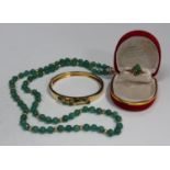 A gold, jade and diamond oval hinged bangle, the front with an applied spray motif, on a snap clasp,