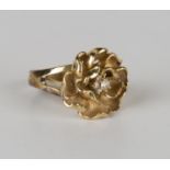 A gold and diamond cluster ring in an abstract floral design between split shoulders, detailed '