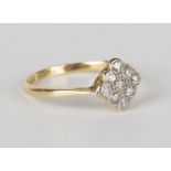 A gold, platinum and diamond nine stone cluster ring in a lozenge shaped design, mounted with