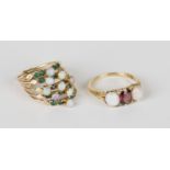 A gold ring, mounted with an oval cut garnet between two oval opals with two pairs of rose cut