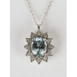 A white gold, aquamarine and diamond pendant, claw set with an oval cut aquamarine within a surround