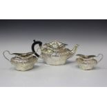An Edwardian silver three-piece tea set, each of ogee baluster form with foliate scrolling