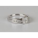 A platinum and diamond ring, mounted with four princess cut diamonds between circular cut diamonds