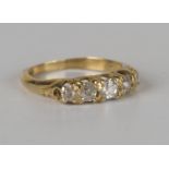 A gold and diamond five stone ring, mounted with a row of cushion cut diamonds graduating in size to