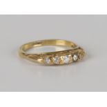 A gold and diamond five stone ring, mounted with a row of cushion cut diamonds graduating in size to