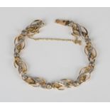 A French two colour gold and diamond bracelet, each link in a scrolling design, mounted with rose