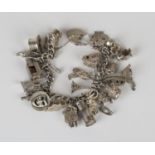 A curblink charm bracelet, fitted with a variety of mostly silver charms, including a cottage, a