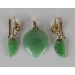 A pair of gold mounted jade pendant earrings, each jade drop carved as a leaf, the gold surmounts