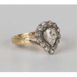 A gold and diamond ring, collet set with a pear shaped diamond within a surround of rose cut