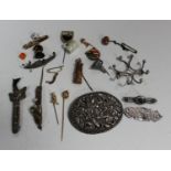 A group of jewellery, including four mostly silver brooches, a charm bracelet, various loose charms,