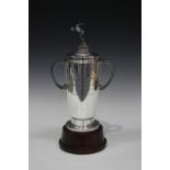 A George VI silver trophy cup and cover with an ice skater finial, the tapering cylindrical body