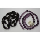 A garnet cluster bead necklace, length 67cm, and a graduated mauve paste bead necklace.Buyer’s