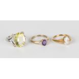 A 9ct gold ring, claw set with an oval cut amethyst between diamond six stone shoulders, ring size