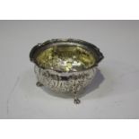 A George II silver circular bowl with cast scroll rim, the body later chased with flowers and