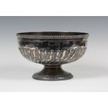 A late Victorian silver rose bowl, the half-reeded and fluted body beneath a gadrooned rim, on a