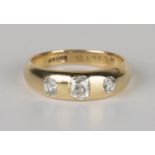 A Victorian 18ct gold and diamond three stone ring, gypsy set with a row of cushion cut diamonds,