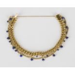 A gold and lapis lazuli bead bracelet in a two row multiple chain link and fringe design, the