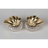 A pair of gold and diamond earrings, each in a stylized crescent and fan shaped design, set with