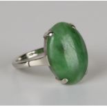 A white gold ring, claw set with an oval jade cabochon, detailed '9ct', ring size approx L1/2,