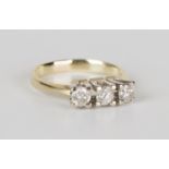 A gold and diamond three stone ring, claw set with a row of circular cut diamonds, detailed '585',