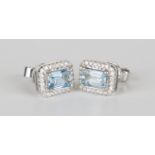 A pair of white gold, aquamarine and diamond earrings, each claw set with a rectangular cut