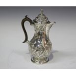 A late Victorian silver coffee pot of baluster form, embossed with scrolling foliage, London 1899 by